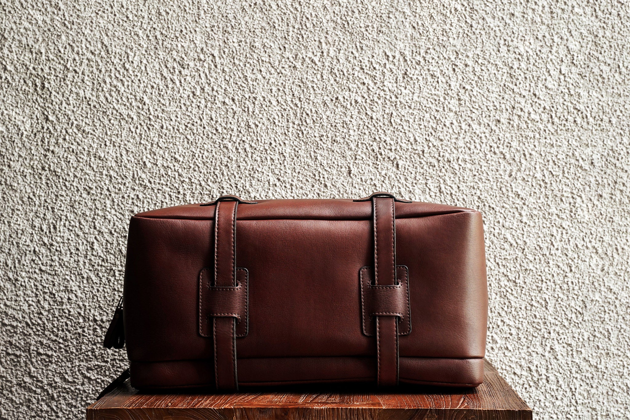 One of our signature design cues, the body straps go all around the bag, providing a load bearing structure for the bag. A big piece of leather on the bottom adds to the durability of the bag.