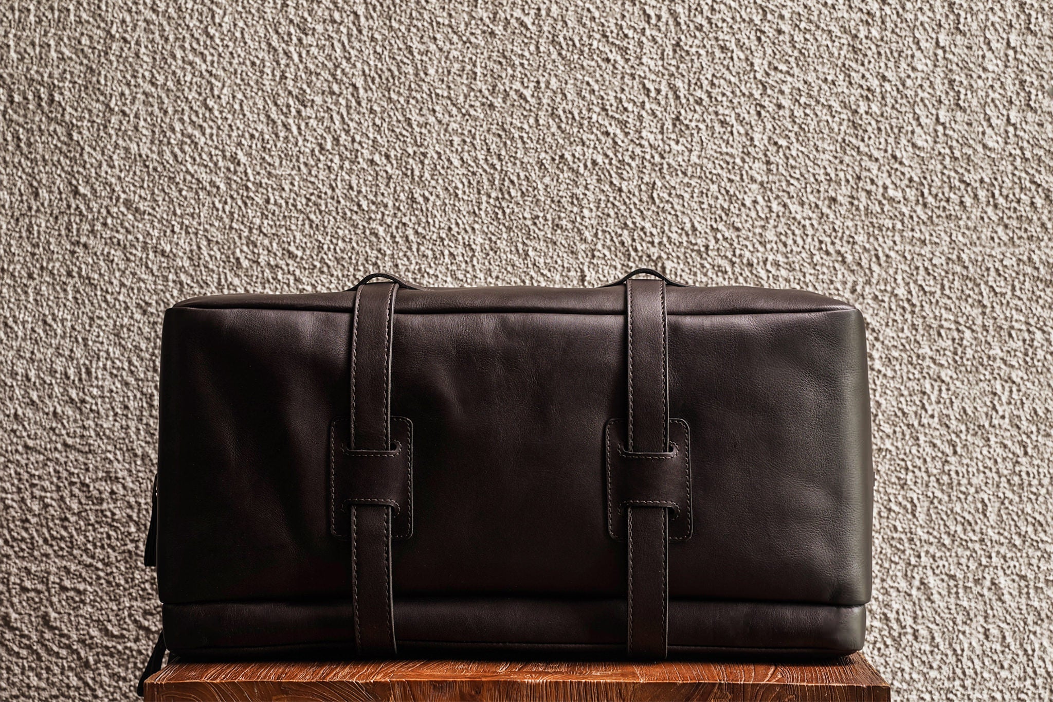 One of our signature design cues, the body straps go all around the bag, providing a load bearing structure for the bag. A big piece of leather on the bottom adds to the durability of the bag.