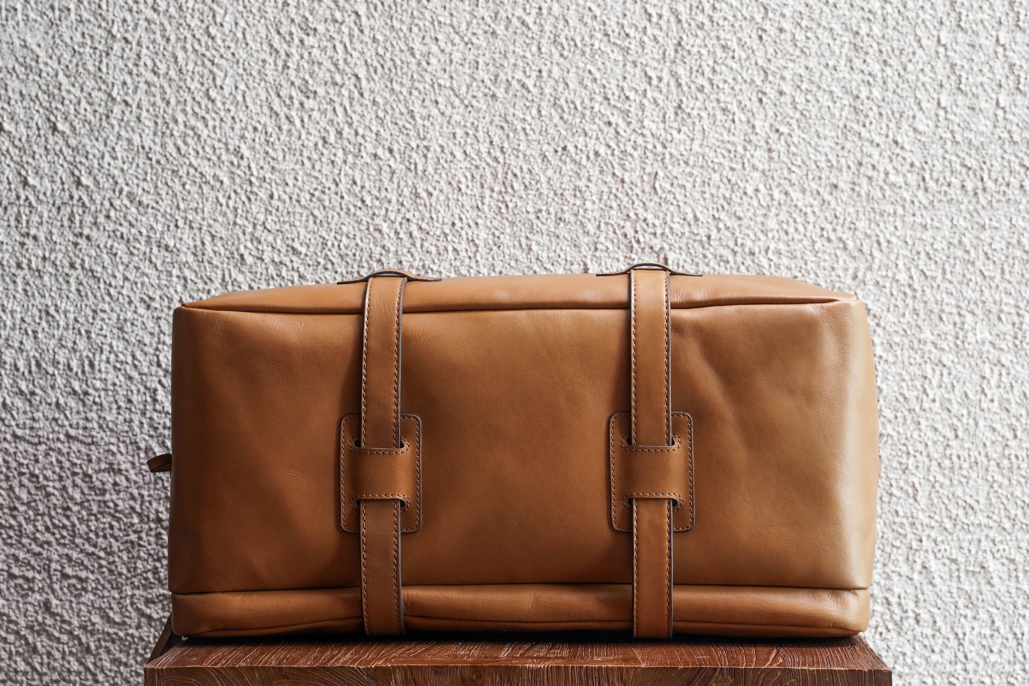 One of our signature design cues, the body straps go all around the bag, providing a load bearing structure for the bag. A big piece of leather on the bottom adds to the durability of the bag.