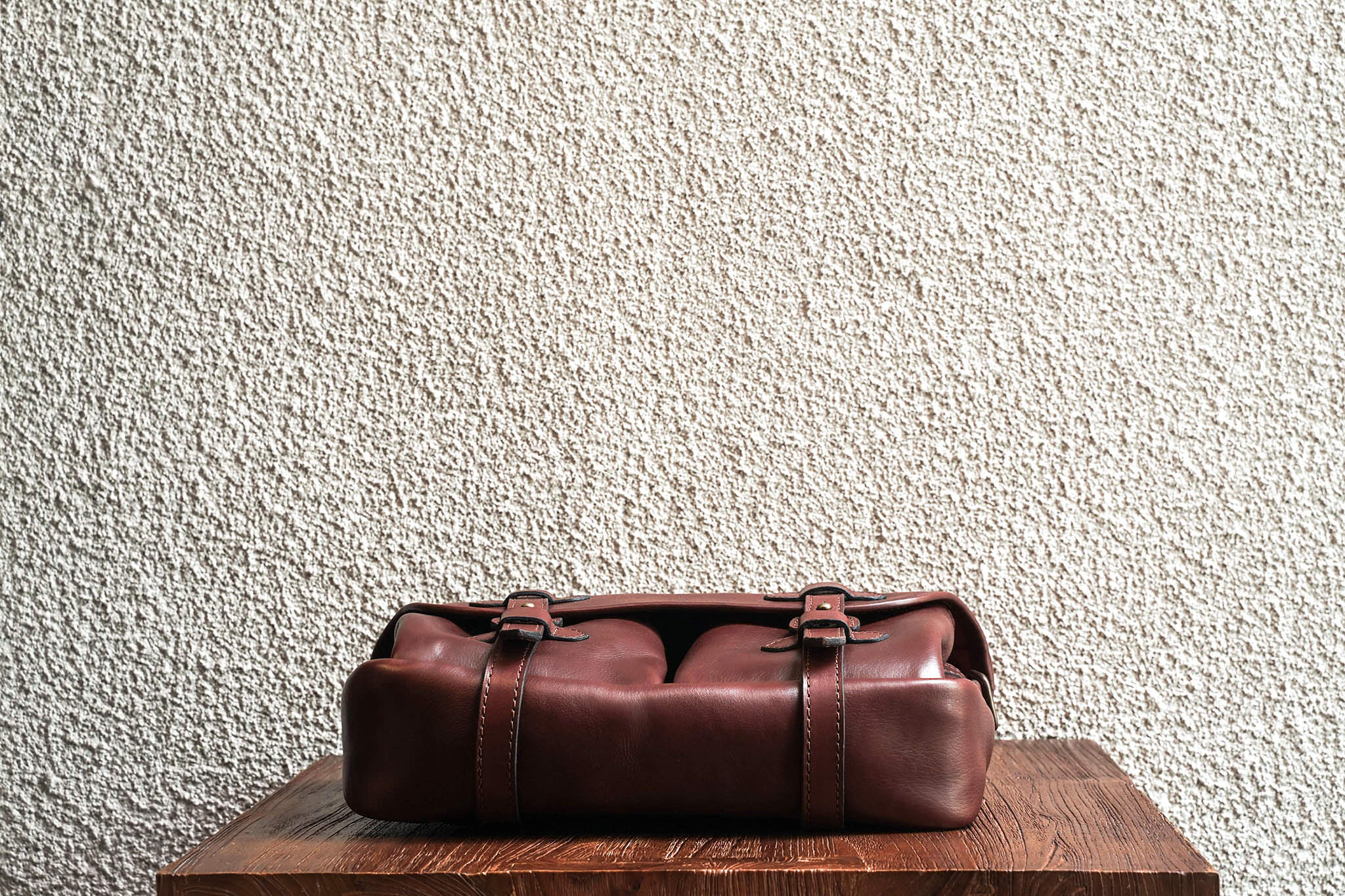 One of our signature design cues, the body straps go all around the bag, providing a load bearing structure for the bag. Keeping with the goal to minimize seams, the sides and bottom are made from one big piece of leather.