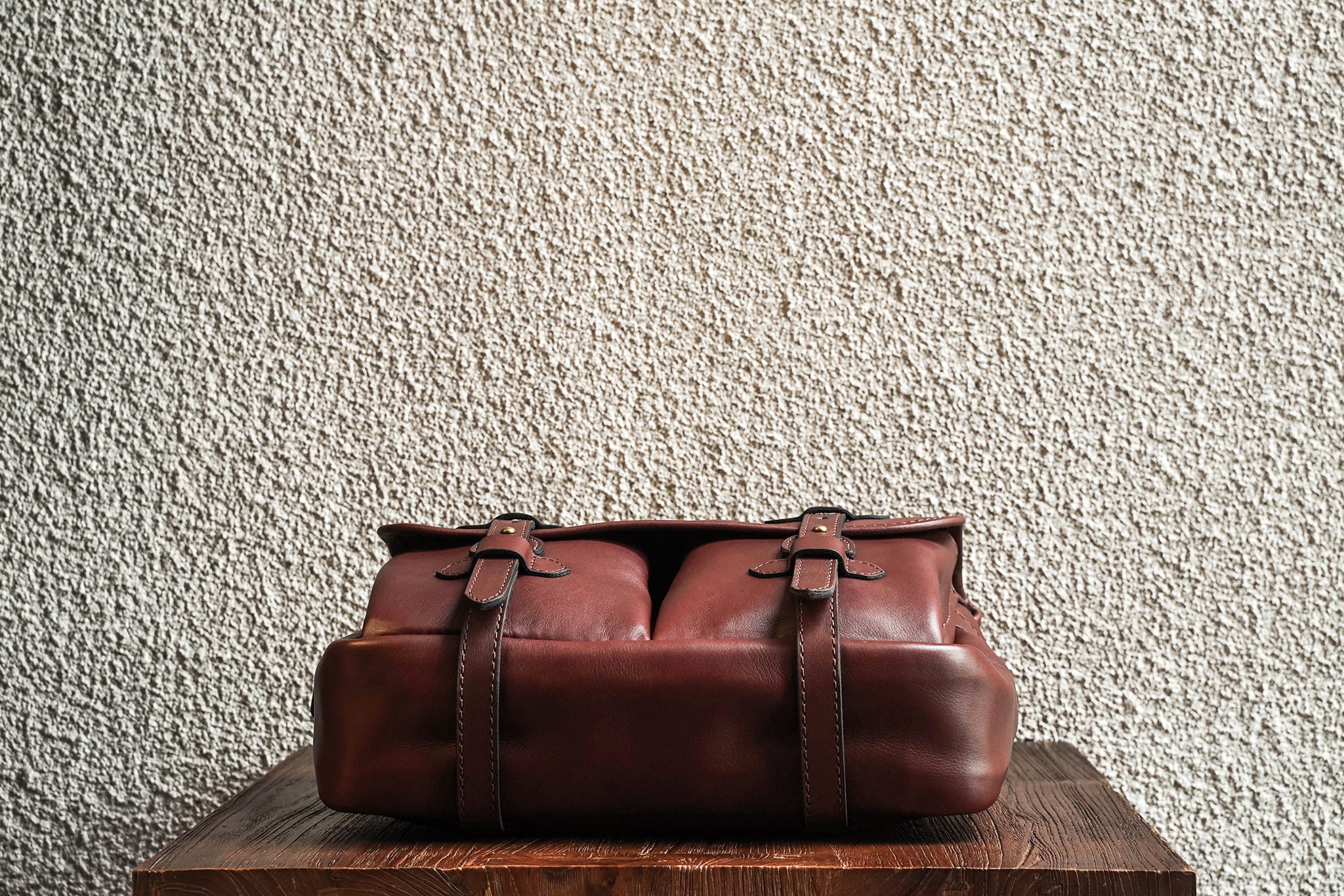 One of our signature design cues, the body straps go all around the bag, providing a load bearing structure for the bag. Keeping with the goal to minimize seams, the sides and bottom are made from one big piece of leather.