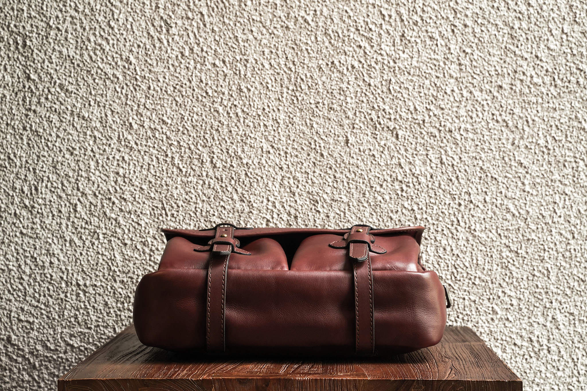 One of our signature design cues, the body straps go all around the bag, providing a load bearing structure for the bag. Keeping with the goal to minimize seams, the sides and bottom are made from one big piece of leather.