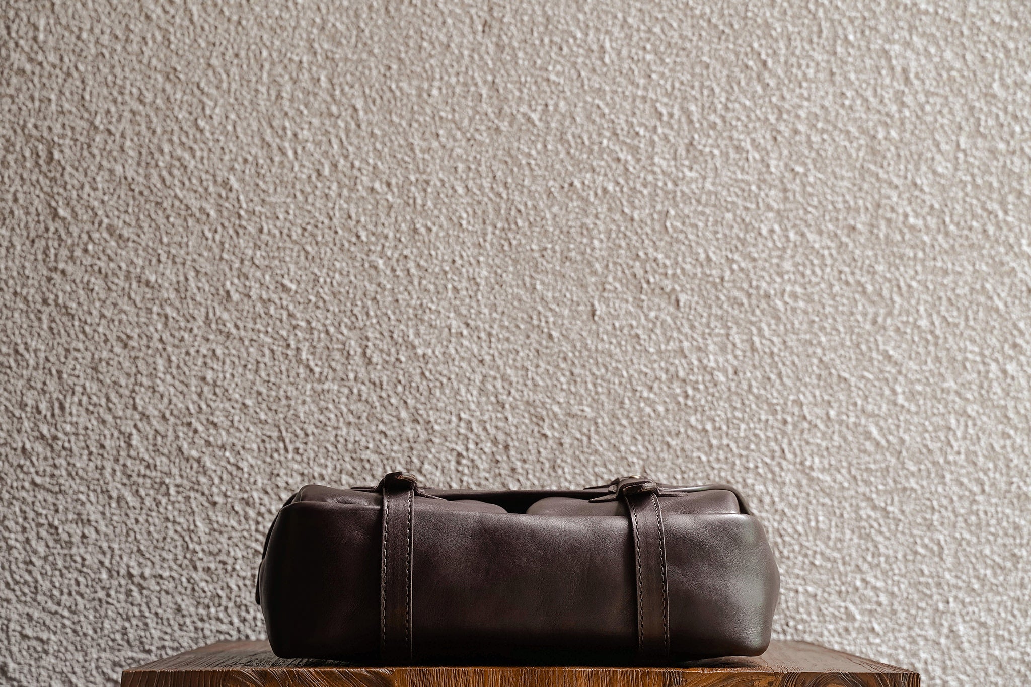 One of our signature design cues, the body straps go all around the bag, providing a load bearing structure for the bag. Keeping with the goal to minimize seams, the sides and bottom are made from one big piece of leather.