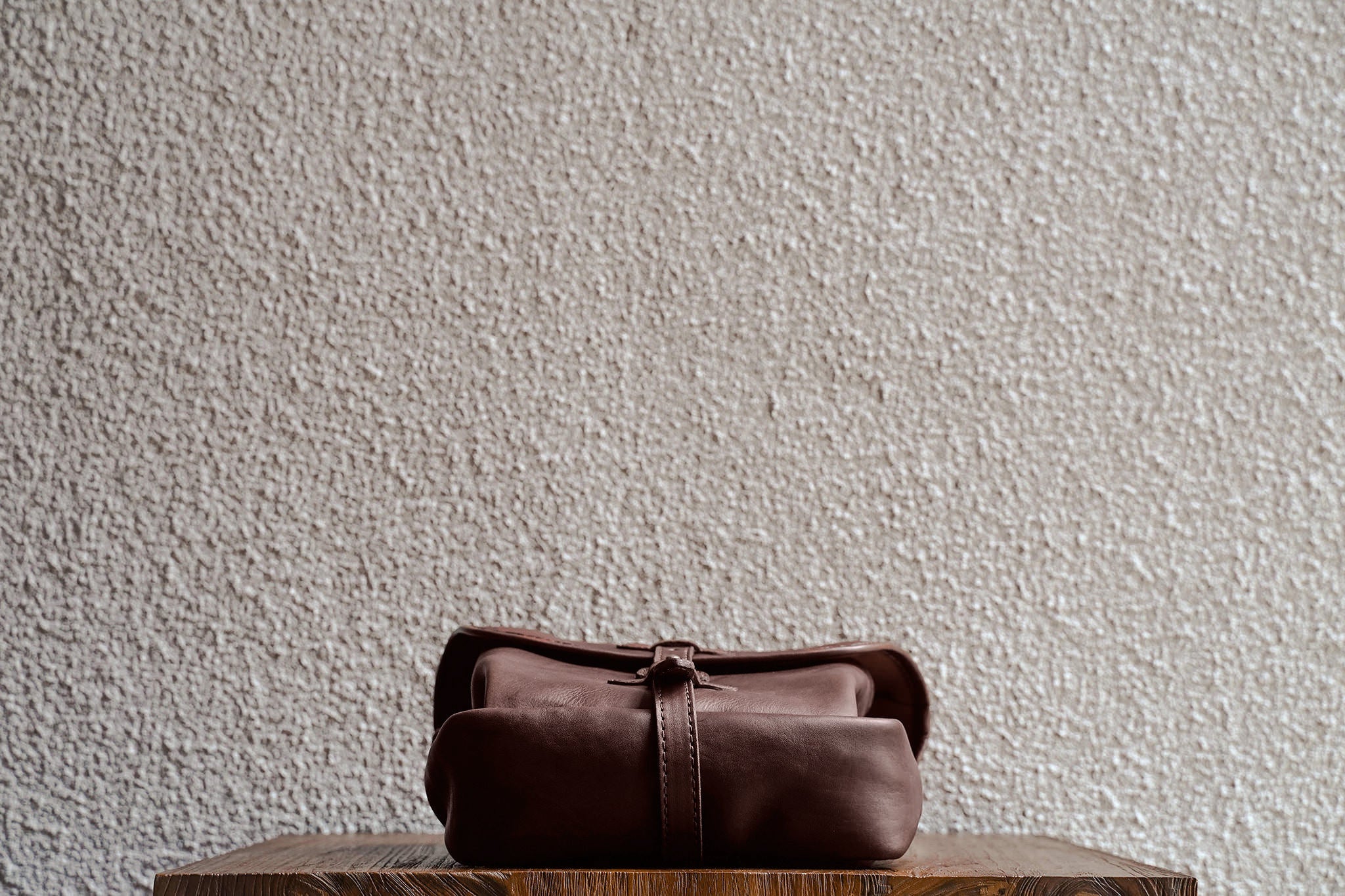 One of our signature design cues, the body strap goes all around the bag, providing a load bearing structure for the bag. Keeping with the goal to minimize seams, the sides and bottom are made from one big piece of leather.